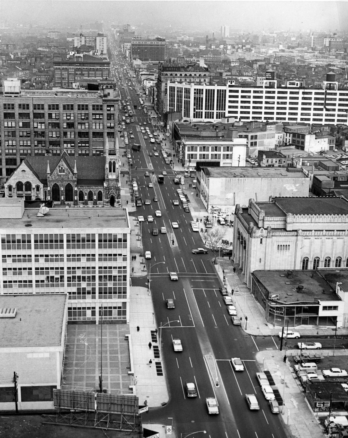 Noon traffic on Broad Street in 1963, photographed from the 18th floor of the State Office Building, with a Gothic church, an ornate stone facade, and a parking garage